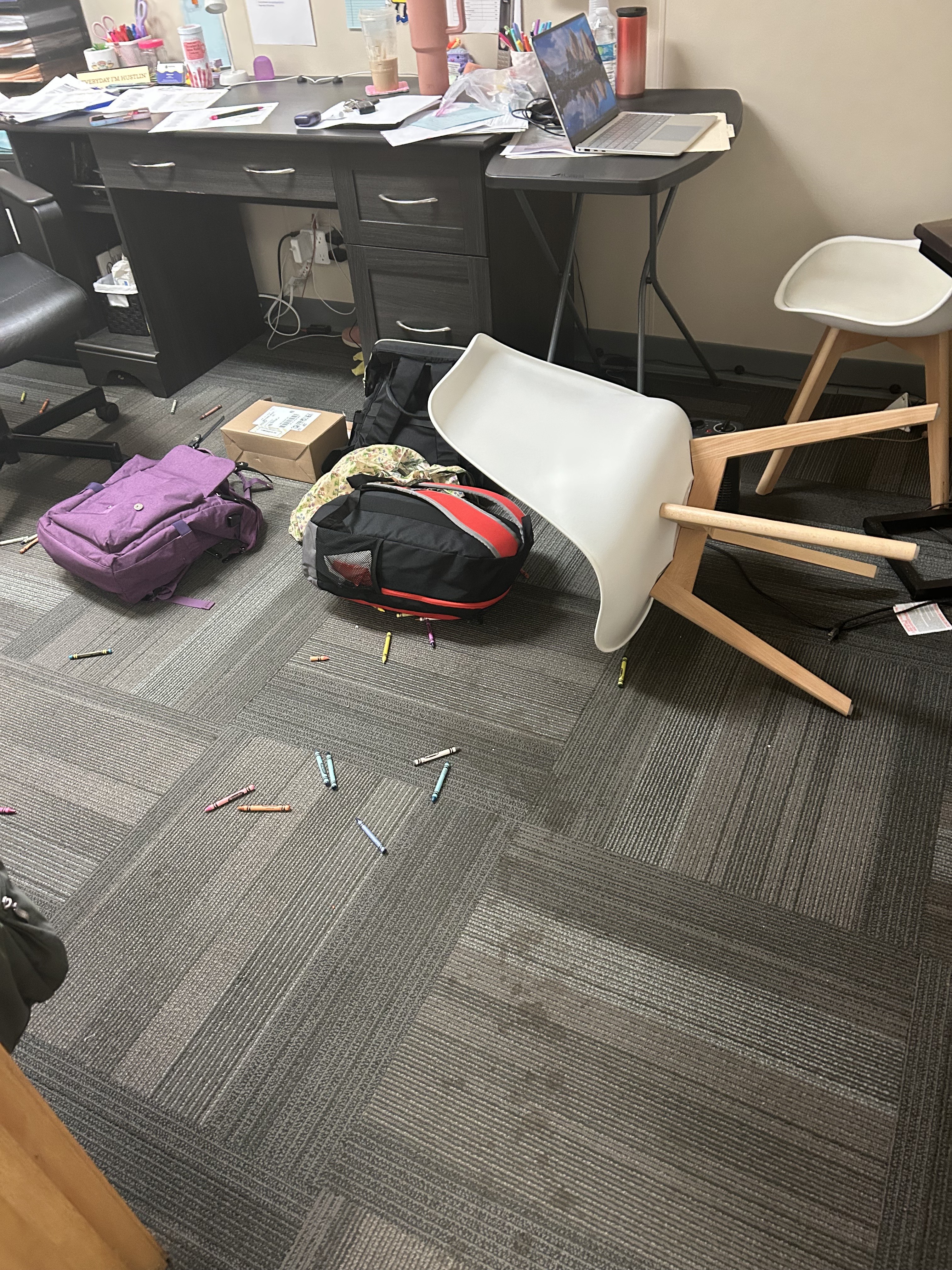 Classroom mess with crayons and overturned chairs